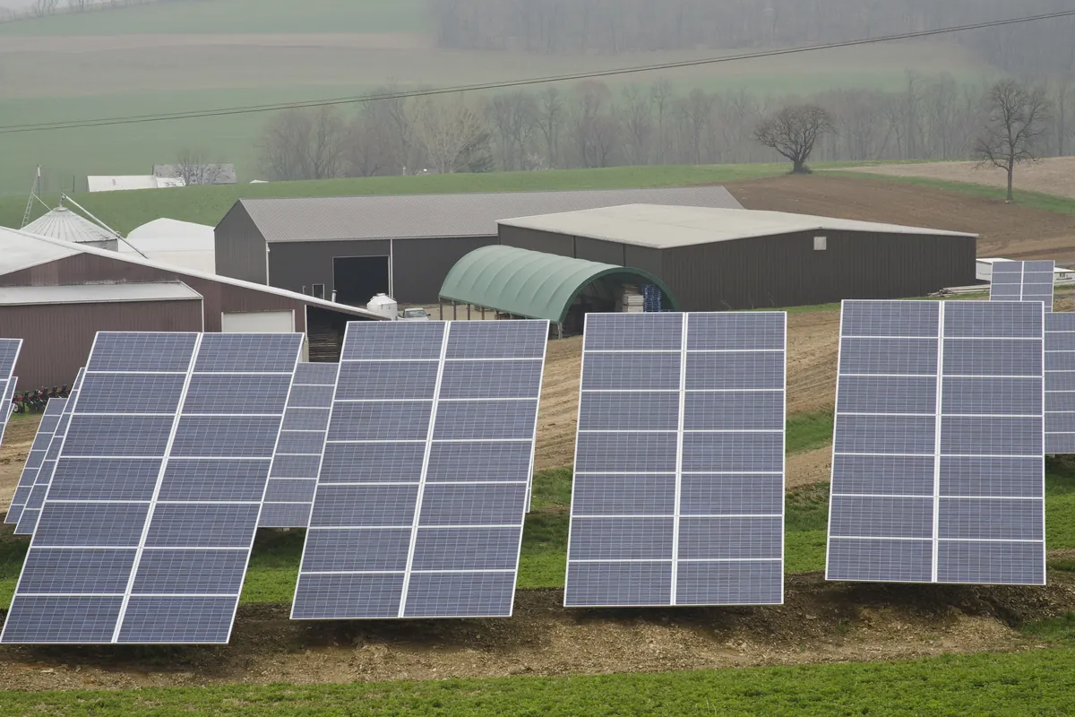 Paneles solares sobre suelo junto a una vivienda rural